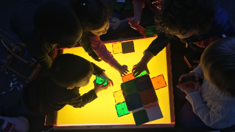 Barn vid ett ljusbord.